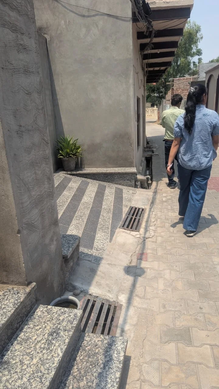 Team members walking along a lane during a Rurka Kalan village visit