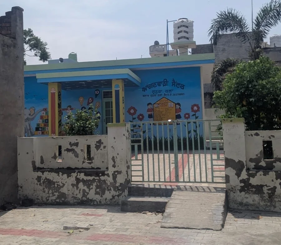 A blue-painted building and entrance gate photographed in Rurka Kalan
